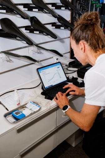 Anne Haug analysing measurement data on a laptop in the bike fitting studio
